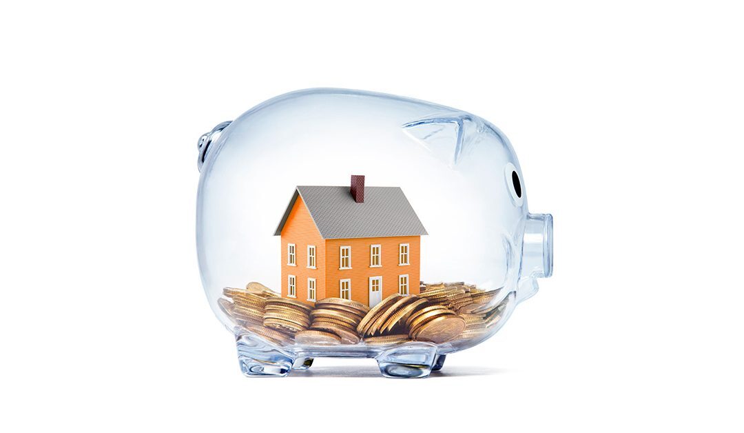 Haus in einem gläsernen Sparschwein mit Geld | Immobilienbewertung