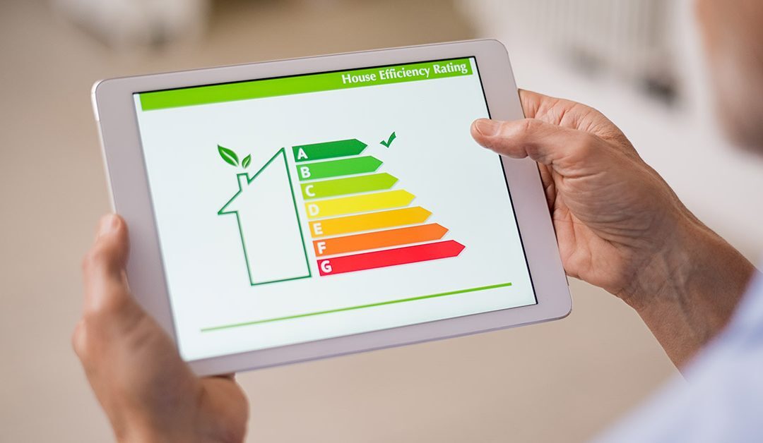 Ein Mann schaut auf ein Tablet, das die Energiebilanz seines Hauses anzeigt | Energieausweis